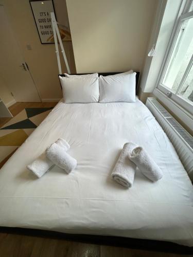a bed with two pairs of socks on it at Flat 1, 128A Belsize Road NW6 4BG LONDON in London