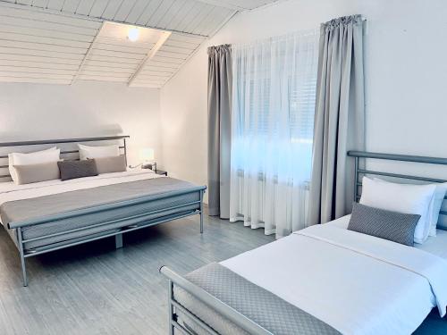1 dormitorio con 2 camas y ventana en Rooms Mirabella, en Rakovica
