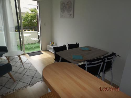 une table et des chaises dans une pièce avec une fenêtre dans l'établissement LA ROCHELLE MIRANDE T1BIS, à La Rochelle