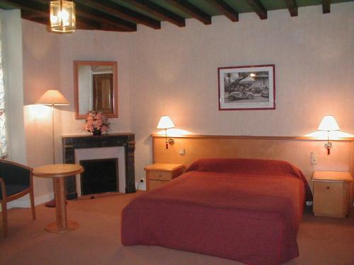 a bedroom with a red bed and a fireplace at Les Lilas Des Deux Ponts in Cravant