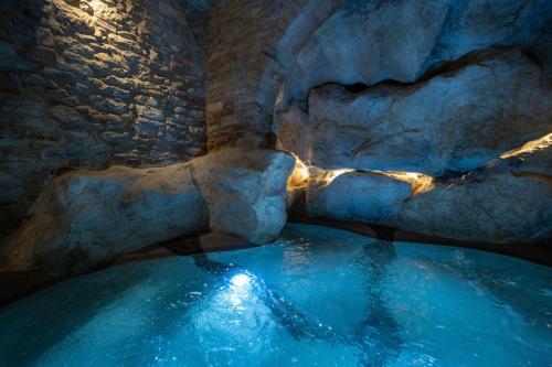 a pool of water in a cave with rocks at Forma Your Boutique Suite in Corciano