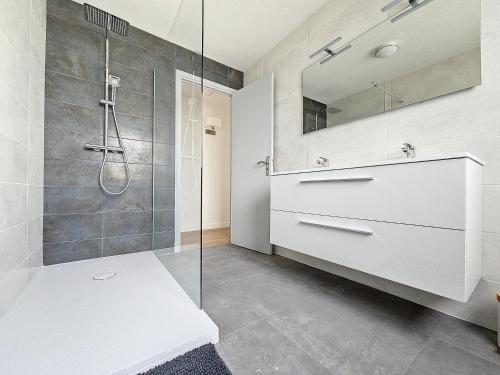 a bathroom with a shower and a sink and a mirror at Minven in Concarneau