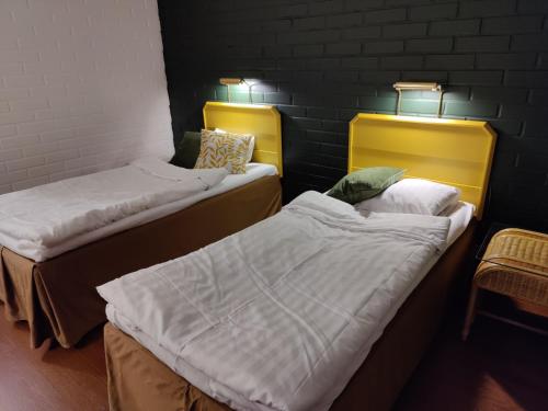 a room with two beds and two lamps at Jokirannan Majoitus in Kokemäki