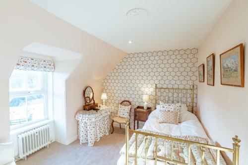 a bedroom with a bed and a desk and a window at Kenmure Kennels in New Galloway