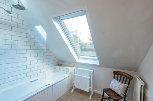 a bathroom with a bath tub and a window at Kenmure Kennels in New Galloway