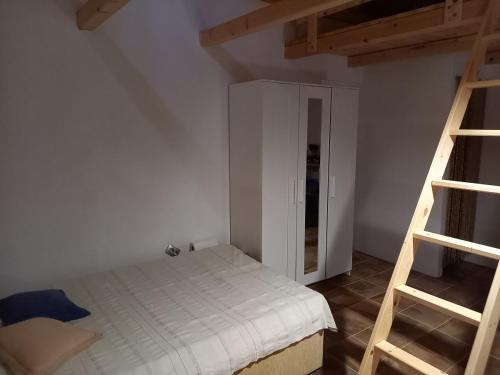 ein kleines Schlafzimmer mit einem Bett und einer Leiter in der Unterkunft Mala oaza in Vrisnik