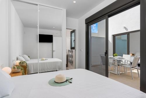 un dormitorio con una cama blanca con sombrero en Santiago Sunny Seabreeze Villa, en Santiago de la Ribera