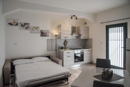 a bedroom with a bed and a table and a kitchen at QUEEN appartamenti e camere in Campofilone