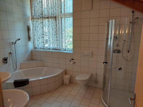 a bathroom with a tub and a toilet and a shower at Michl's Villa in Tarrenz