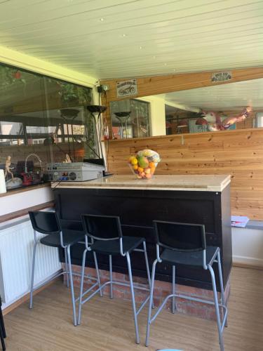 a kitchen with a counter with chairs and a bowl of fruit at Family Holiday Home in Blackpool