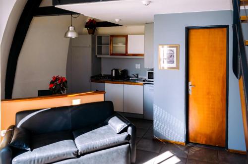 uma sala de estar com um sofá e uma cozinha em Rosario Suites em Rosário