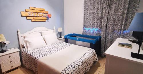 a small bedroom with a bed and a desk with a lamp at Salitre in La Caleta