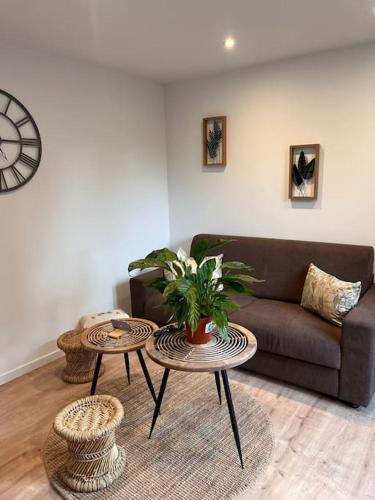 a living room with a couch and two tables at Beau Loft room proche mont saint Michel jaccuzi illimité en plein centre Avranches in Avranches