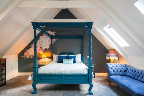 a blue bed in a attic bedroom with a blue couch at The Crag in Wadebridge