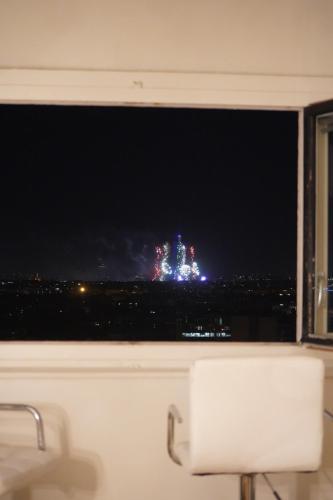 Vue panoramique sur Paris : Sublime appartement au centre de Courbevoie في كوربفوا: نافذة مطلة على قلعة في الليل