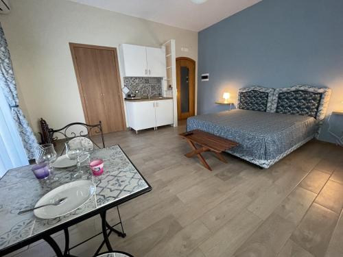 a living room with a bed and a table with plates on it at Namastè Apartments Agrigento in Agrigento
