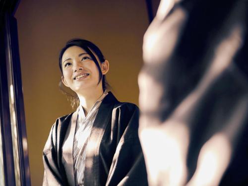 a woman looking at her reflection in a mirror at Kansyokan in Mogami