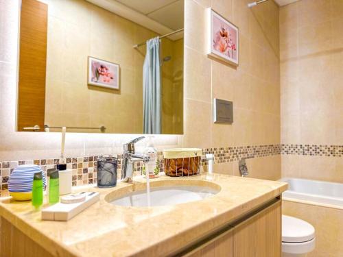 een badkamer met een wastafel, een toilet en een spiegel bij Luxury Golf View For Family 203A3 in Abu Dhabi