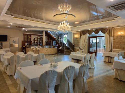 a banquet hall with white tables and chairs at Hotel Viwaldi in Baruchowo