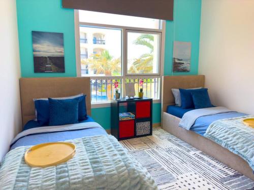 1 dormitorio con 2 camas y 2 ventanas en Luxury Golf View For Family 203A3, en Abu Dabi