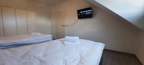 a room with two beds and a tv on the wall at Penzini Apartment in unmittelbarer Nähe zur Messe Karlsruhe in Rheinstetten