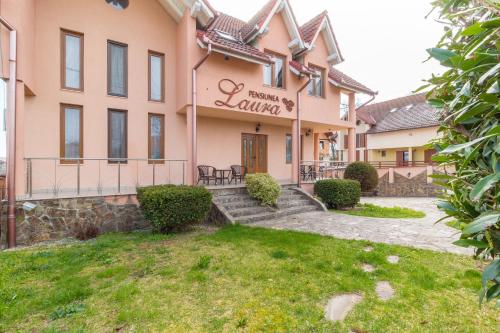 a building with a sign that reads prairie village at Pensiunea Laura in Sînmartin