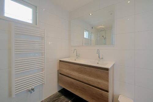 un baño con lavabo y espejo en Vakantiehuis Duyngans - Julianadorp aan Zee, en Julianadorp