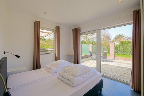 Un dormitorio con una cama y una puerta corrediza de vidrio. en Vakantiehuis Duyngans - Julianadorp aan Zee, en Julianadorp