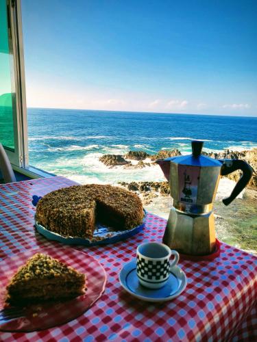 CuatunalcoにあるHotel Luz de Mar ' right on the beachのケーキとティーポットとコーヒーカップが置かれたテーブル