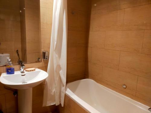 a bathroom with a sink and a bath tub and a sink at Sea View Studio 5 Royal Breeze سي ويو ستوديو رويال بريز in Ras al Khaimah