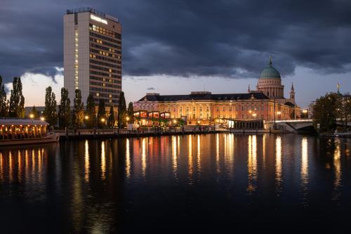 una ciudad con un edificio y un río por la noche en Mercure Hotel Potsdam City, en Potsdam