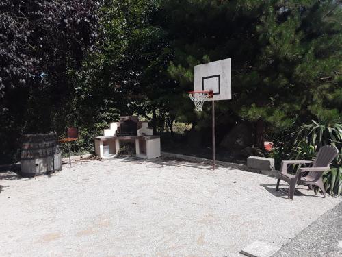 a basketball hoop and a chair in a yard at Gîte à la campagne 1 in Sainteny