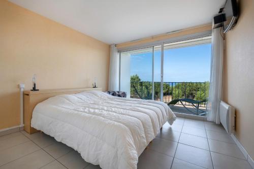 une chambre avec un grand lit et une grande fenêtre dans l'établissement Face mer appartement pour 4 à Saint Brévin, à Saint-Brévin-les-Pins