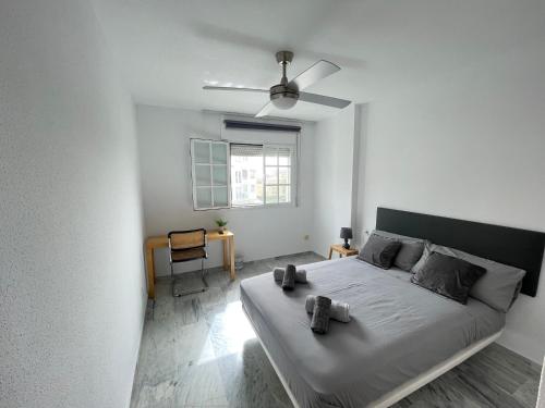 a white bedroom with a bed with a ceiling fan at Casa Sol & Mar, Rincon de la Victoria, Malaga in Rincón de la Victoria