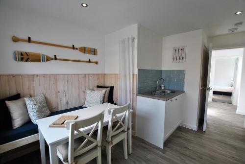 a kitchen and dining room with a table and a sink at Murrays Neuk- stylish coastal apartment in Anstruther