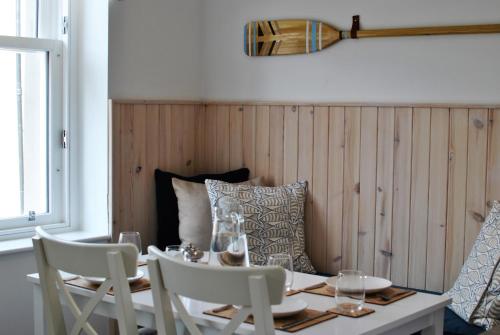 a dining room with a table and chairs with glasses on it at Murrays Neuk- stylish coastal apartment in Anstruther