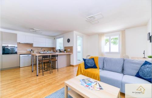 un salon avec un canapé bleu et une cuisine dans l'établissement R'Apparts T3 The Forest, à Grenoble