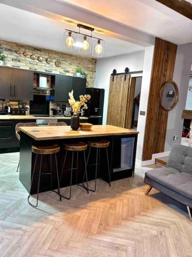 a kitchen with a large island with bar stools at Large Peak District National Park Holiday House in Hadfield