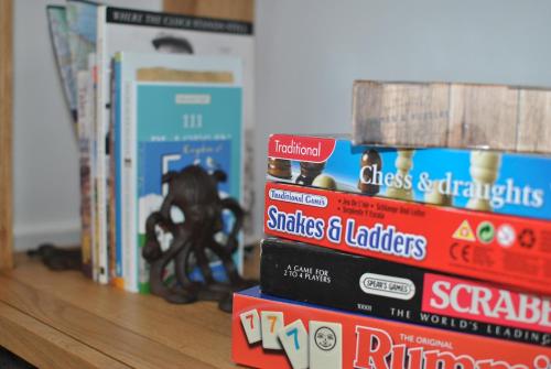 a stack of books sitting on a shelf at Murrays Neuk- stylish coastal apartment in Anstruther