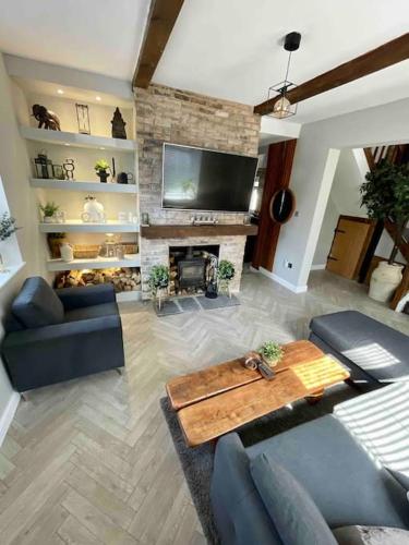 a living room with a couch and a table and a fireplace at Large Peak District National Park Holiday House in Hadfield
