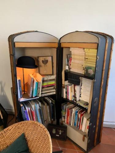 deux étagères remplies de livres à côté d'une lampe dans l'établissement Maison charmante au bord du Rhône., à Arles