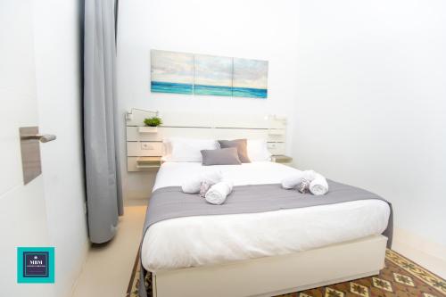 a bedroom with a bed with white sheets and pillows at Vegueta Old Town, Las Palmas in Las Palmas de Gran Canaria