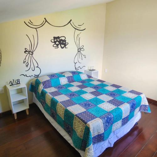 a bedroom with a bed with a checkered blanket at Vila Barroca Estalagem in São Cristóvão