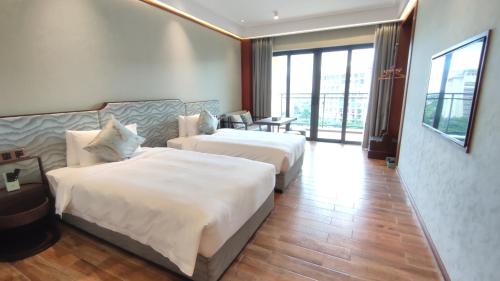 a hotel room with two beds in a room at Zhongzhou International Apartment in Sanya