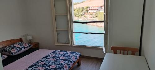 Dormitorio con ventana, cama y mesa en Primitivo Bay Hvar, en Hvar