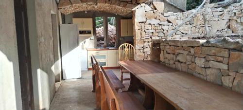 a kitchen with a wooden bench and a stone wall at Primitivo Bay Hvar in Hvar