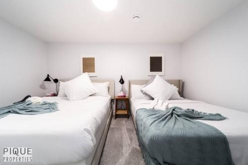 zwei nebeneinander stehende Betten in einem Schlafzimmer in der Unterkunft Urban Utopia - Hot Tub - King Bed - BBQ - Sleeps 16 - Garage in Edmonton