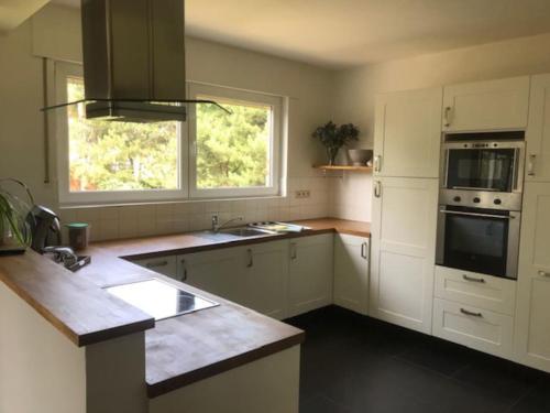 a kitchen with white cabinets and a window at Fokus Time out in Dessel