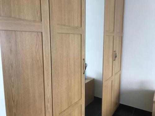 a pair of wooden closet doors in a room at Fokus Time out in Dessel
