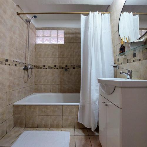 W łazience znajduje się wanna i umywalka. w obiekcie Estudio Pinar del Lago w mieście Bariloche